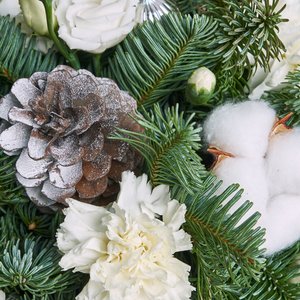 Белоснежный букет нежных цветов с зимним нобилсом и шишками